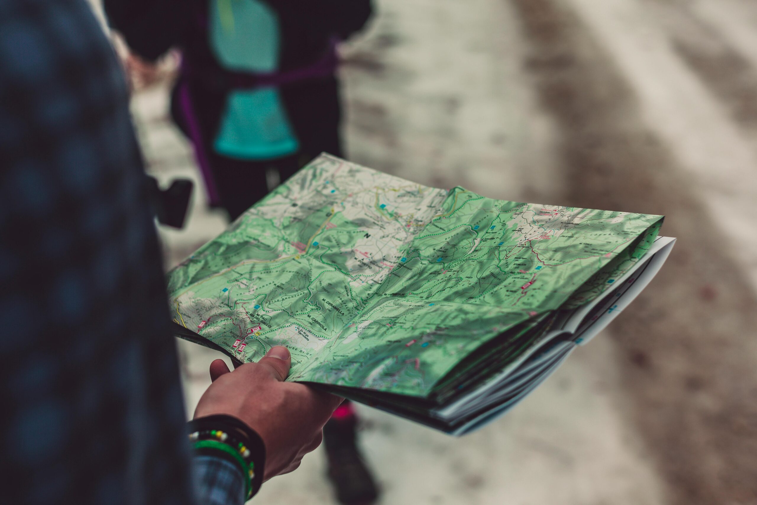 A close-up of a person holding a detailed route map outdoors, ideal for travel and exploration themes.